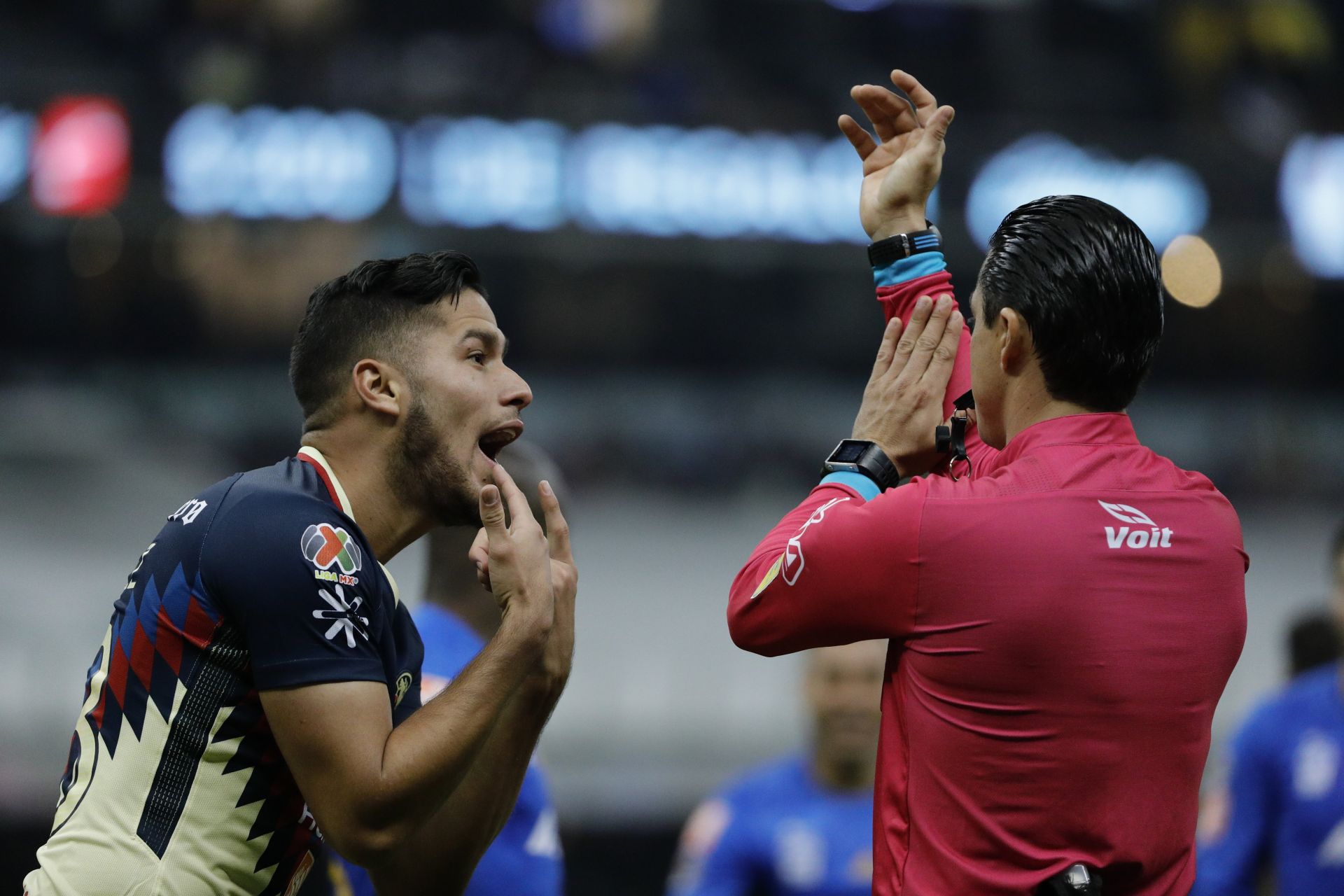 El jugador de América Bruno Valdez (i) reclama un penal contra Tigres al arbitro Oscar Macias (d).