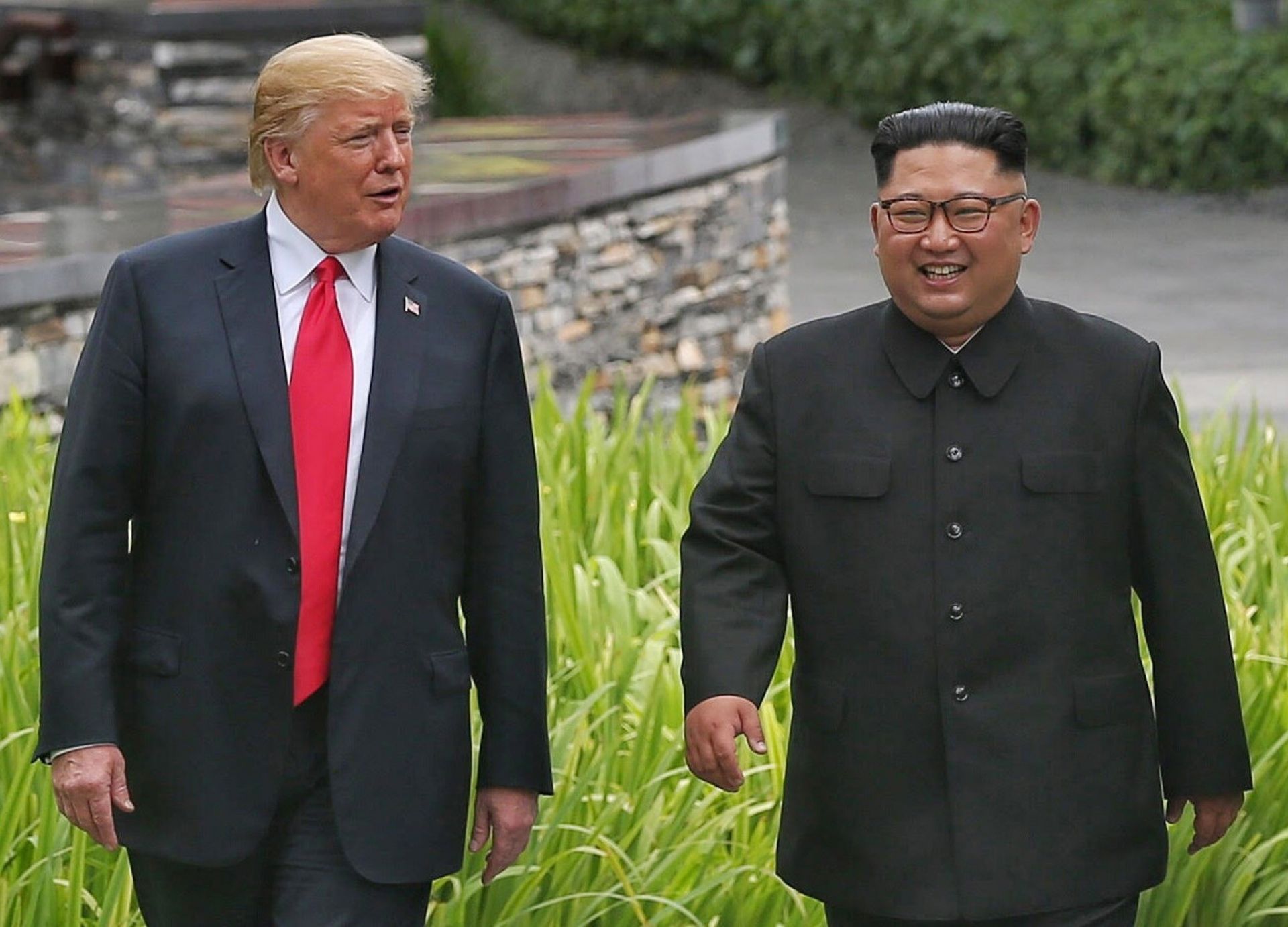 El presidente estadounidense, Donald J. Trump (i), y el líder norcoreano, Kim Jong-un, dan un paseo por los jardines del hotel Capella tras asistir a un almuerzo de trabajo